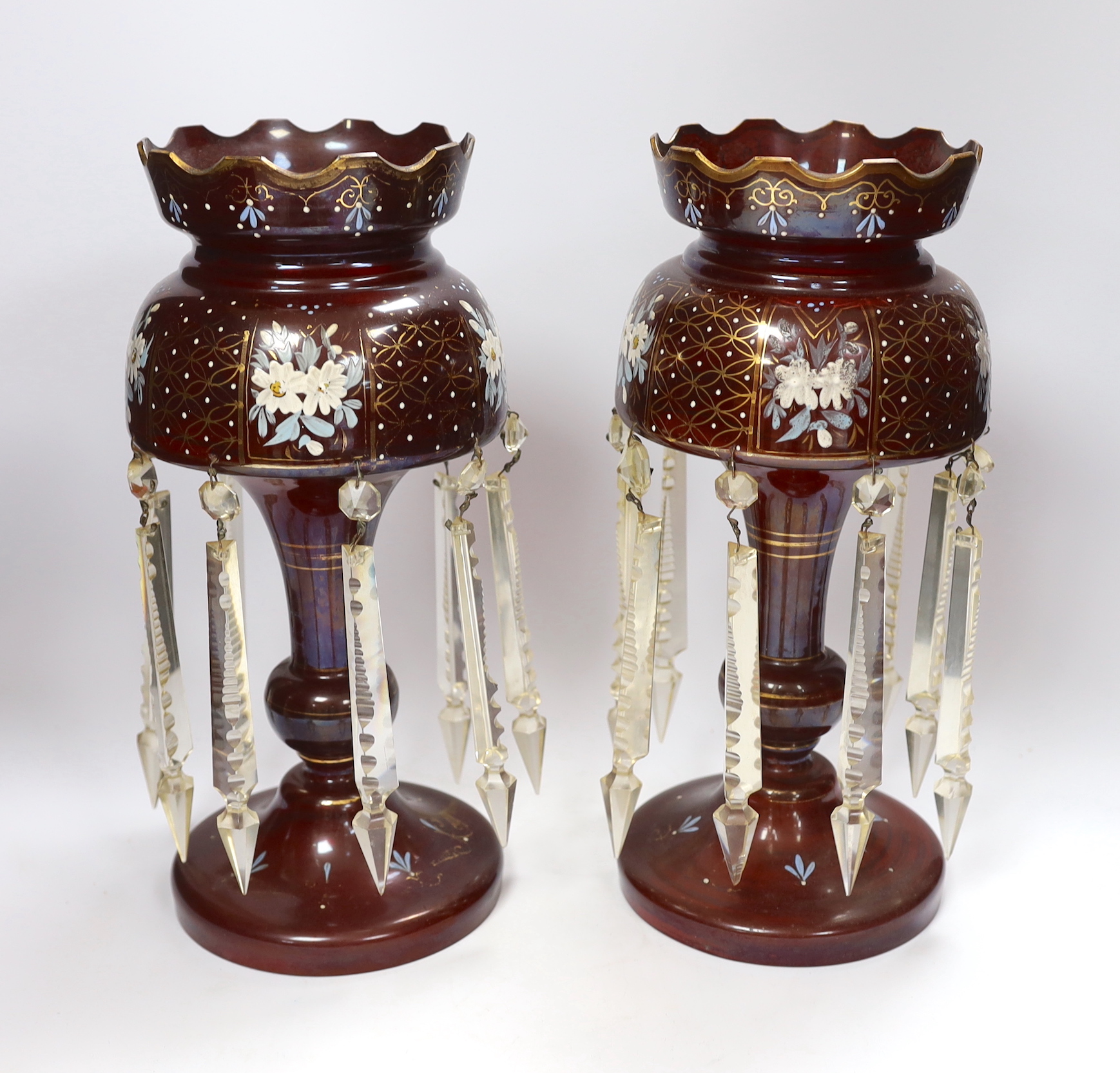 A pair of late 19th century ruby glass floral enamelled table lustres, 35.5cm high